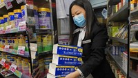 Seorang petugas membawa sejumlah dus masker untuk dijual kepada warga yang telah mengantre untuk membeli masker di kawasan Hong Kong. AP Photo/Vincent Yu.