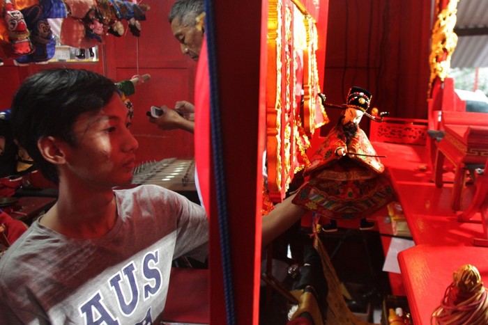Penonton melihat Pergelaran Wayang Potehi dengan lakon Hwee Liong Toan atau Kisah Naga Api di Klenteng En Ang Kiong, Malang, Jawa Timur, Kamis (30/1/2020). Pergelaran yang diadakan selama satu minggu tersebut untuk memeriahkan tahun baru Imlek dan menyambut perayaan hari Cap Go Meh. ANTARA FOTO/Ari Bowo Sucipto/ama.
