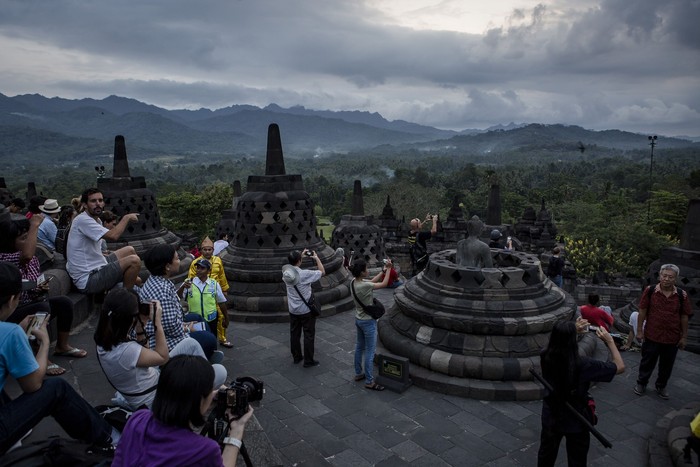 MAGELANG, CENTRAL JAVA, INDONESIA - MAY 10: Tourists at Borobudur temple during celebrations for Vesak Day on May 10, 2017 in Magelang, Central Java, Indonesia. Buddhists in Indonesia celebrate Vesak at the Borobudur temple annually, which makes it the most visited tourist attraction in Indonesia. It is observed during the full moon in May or June, with the ceremony centered at three Buddhist temples by walking from Mendut to Pawon and ending at Borobudur. The stages of life of Buddhism's founder, Gautama Buddha, which are celebrated at Vesak are his birth, enlightenment to Nirvana, and his passing (Parinirvana). (Photo by Ulet Ifansasti/Getty Images)