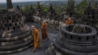 Sesekali pengunjung bisa melihat para biksu berdoa di jajaran patung Buddha di atas candi. (Getty Images)