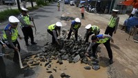 Begini suasana saat sejumlah personel polisi dari Polresta Bandar Lampung bergotong-royong memperbaiki jalan rusak di Jalan Ryacudu, Kamis (30/1/2020).