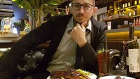 Dengan menopang dagu, begini pose Mr. Dennis saat ingin menyantap makanan di hadapannya. Dalam unggahan ini, ia juga sambil mengajarkan Bahas Inggris untuk menyebut Selamat Makan.  Foto: Instagram @gurukumrd