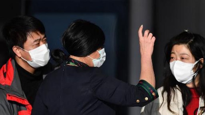 A company employee (C) assists passengers waiting to check in by the counter of China Southern Airlines at Romes Fiumicino airport for a flight returning to Wuhan, China, after it landed early on January 23, 2020. - China banned trains and planes from leaving a major city at the centre of a virus outbreak on January 23, seeking to seal off its 11 million people to contain the contagious disease that has claimed 17 lives, infected hundreds and spread to other countries. (Photo by Tiziana FABI / AFP)
