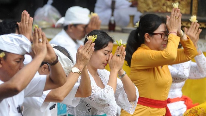 Pemuka agama Hindu memercikkan air suci saat persembahyangan bersama di Pura Luhur Candi Narmada Tanah Kilap, Denpasar, Bali, Jumat (31/1/2020). Persembahyangan yang dilakukan Dinas Pariwisata Provinsi Bali dan diikuti sejumlah pelaku industri pariwisata tersebut diselenggarakan untuk mendoakan keselamatan dunia dan memohon agar Bali dijauhkan dari penyebaran virus Corona. ANTARA FOTO/Fikri Yusuf/nz