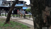 Seorang warga tampak duduk di bangku taman yang disediakan di RTH yang berada di kawasan Manggarai tersebut.