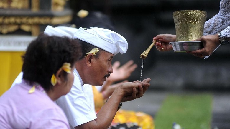 SEMBAHYANG BERSAMA TERKAIT VIRUS CORONA Pemuka agama Hindu memercikkan air suci saat persembahyangan bersama di Pura Luhur Candi Narmada Tanah Kilap, Denpasar, Bali, Jumat (31/1/2020). Persembahyangan yang dilakukan Dinas Pariwisata Provinsi Bali dan diikuti sejumlah pelaku industri pariwisata tersebut diselenggarakan untuk mendoakan keselamatan dunia dan memohon agar Bali dijauhkan dari penyebaran virus Corona. ANTARA FOTO/Fikri Yusuf/nz