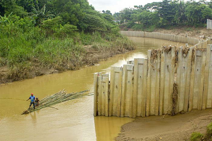 DINDING TURAP ILEGAL SUNGAI CBEET Warga menggunakan perahu rakit saat melintasi sungai Cibeet yang terpasang dinding turap (sheet pile) di Karawang, Jawa Barat, Jumat (31/1/2020). Balai Besar Wilayah Sungai (BBWS) Citarum menyatakan pemasangan dinding turap di tengah sungai Cibeet oleh oknum pengusaha Kabupaten Bekasi tersebut tidak memiliki izin dan dapat mempersempit bentuk sungai serta menyebabkan banjir. ANTARA FOTO/M Ibnu Chazar/nz.
