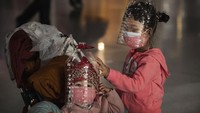 Orangtua dari dua bocah ini sengaja membuatkan helm dari botol plastik sebagai perlindungan ganda agar tak terpapar virus corona. Foto kakak beradik ini dijepret di area Bandara Shanghai. Foto: istimewa