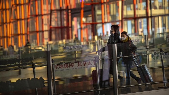 Travelers wearing face masks walk along a concourse at Beijing Capital International Airport in Beijing, Thursday, Jan. 30, 2020. China counted 170 deaths from a new virus Thursday and more countries reported infections, including some spread locally, as foreign evacuees from Chinas worst-hit region returned home to medical observation and even isolation. (AP Photo/Mark Schiefelbein)