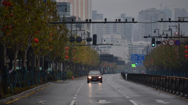 Kota Mati Wuhan A lone car drives down a disserted street in Wuhan on January 26, 2020, a city at the epicentre of a viral outbreak that has killed at least 56 people and infected nearly 2,000. - China on January 26 expanded drastic travel restrictions to contain the viral contagion, as the United States and France prepared to evacuate their citizens from the quarantined city at the outbreak's epicentre. (Photo by Hector RETAMAL / AFP)