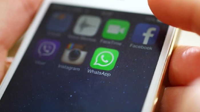 WhatsApp Wien,Austria-February 25,2014: Closeup of female hand holding an iPhone 5s while launching WhatsApp,a popular messaging application .