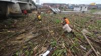 Pasukan Turbo Dinas Pekerjaan Umum dan Perumahan Rakyat (PUPR) Banjarmasin bersama warga dibantu kapal pembersih sungai berusaha membersihkan sampah yang terbawa arus Sungai Martapura di bawah Jembatan Pasar Lama, Banjarmasin, Kalimantan Selatan, Jumat (31/1/2020).