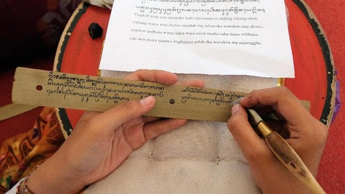 Peserta menuliskan aksara Bali di atas daun lontar dalam festival Nyurat Lontar yaitu rangkaian peringatan Bulan Bahasa Bali 2020 di Taman Budaya Bali, Denpasar, Bali, Sabtu (1/2/2020). Kegiatan yang diikuti 2.020 peserta tersebut merupakan upaya perlindungan dan penggunaan bahasa, aksara serta sastra Bali. ANTARA FOTO/Nyoman Hendra Wibowo/nym/hp.