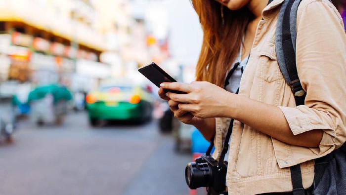 main hp Young Asian female tourist woman using a mobile phone in Bangkok, Thailand. Calling a cab or finding information during traveling concept