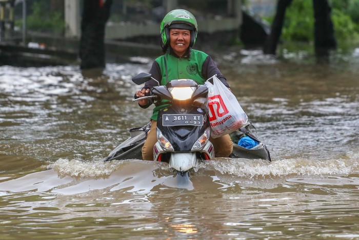 Pengendara melintasi banjir di Jalan Raya Regency, Kota Tangerang, Banten, Sabtu (1/2/2020). Hujan lebat yang mengguyur sejak malam hari menyebabkan beberapa titik di Tangerang terendam banjir. ANTARA FOTO/Fauzan/hp.