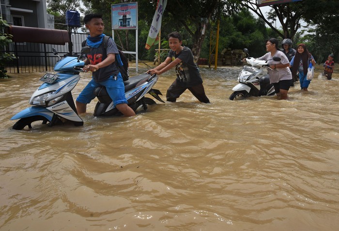TANGKAP BIAWAK TERBAWA BANJIR Warga menangkap biawak yang hanyut terbawa banjir di Walantaka, Serang, Banten, Sabtu (1/2/2020). Banjir terjadi akibat tanggul di lokasi tersebut jebol setelah diguyur hujan sejak Jumat (31/1) malam. ANTARA FOTO/Asep Fathulrahman/ama.