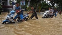Sejumlah warga tengah mendorong sepeda motor yang mogok imbas banjir di kawasan Walantaka, Serang, Banten, Sabtu (1/2/2020).
