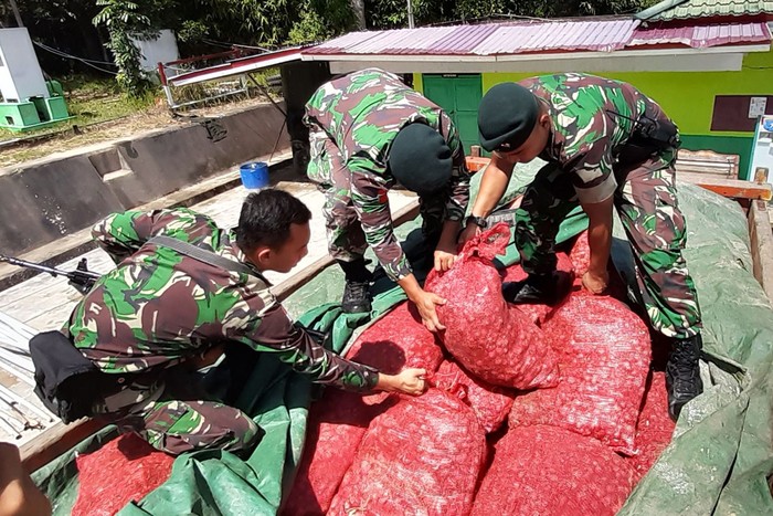 TNI TANGKAP BAWANG MERAH ILEGAL Prajurit TNI Satgas Yonif Raider 641/Bru menunjukkan karung berisi bawang merah illegal asal Malaysia di Pos Kotis Entikong, Kabupaten Sanggau, Kalimantan Barat, Sabtu (1/2/2020). Satgas Yonif Raider 641/Bru di Pos Segumun menangkap truk nopol KB 8968 DC yang membawa 300 karung berisi bawang merah ilegal seberat 5,4 ton asal Malaysia tanpa dokumen resmi di jalan