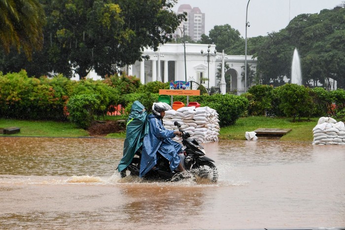Warga mendorong motor melintasi banjir di kawasan Monas, Jalan Medan Merdeka Barat, Jakarta, Minggu (2/2/2020). Hujan deras yang mengguyur Jakarta pada Minggu (2/2) pagi menyebabkan beberapa ruas jalan di ibu kota tergenang banjir dengan ketinggian 10-50 centimeter. ANTARA FOTO/Hafidz Mubarak A/aww.