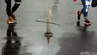 Refleksi Monas di antara dua pengunjung.