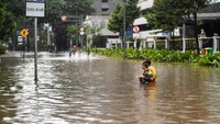 Anak-anak bermain air saat terjadi genangan di Jalan H. Agus Salim, Jakarta.