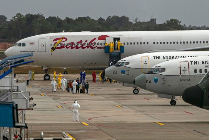 Sebanyak 250 WNI yang dievakuasi dari Kota Wuhan, China turun dari pesawat setibanya di Bandara Hang Nadim, Batam, Kepulauan Riau, Minggu (2/2/2020). WNI yang dievakuasi dari Wuhan tersebut kemudian diterbangkan kembali menuju Ranai, Natuna untuk menjalani observasi. ANTARA FOTO/M N Kanwa/aww.