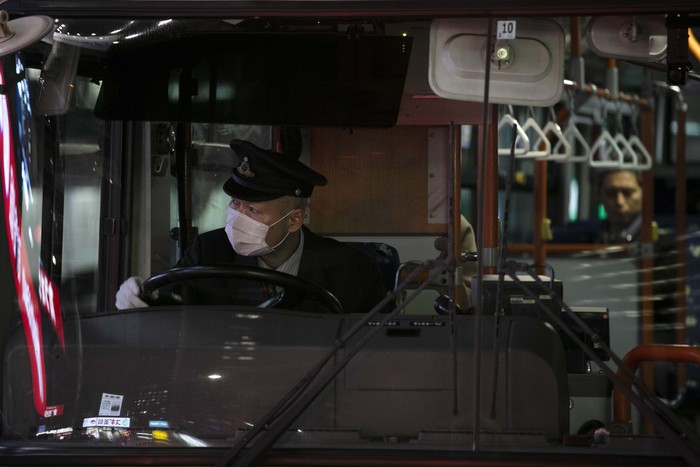 In this Saturday, Feb. 1, 2020, photo released by KBRI Beijing, Indonesian evacuees wearing face masks fill in the registration form at Wuhan airport in China, while waiting to depart for Indonesia. A government-chartered jet departed Jakarta Saturday to evacuate 250 Indonesian nationals from Wuhan. (AP Photo/KBRI Beijing)
