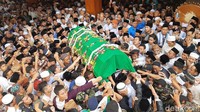 Keranda jenazah Gus Sholah yang dibalut kain hijau digotong ke masjid pesantren untuk disalatkan.