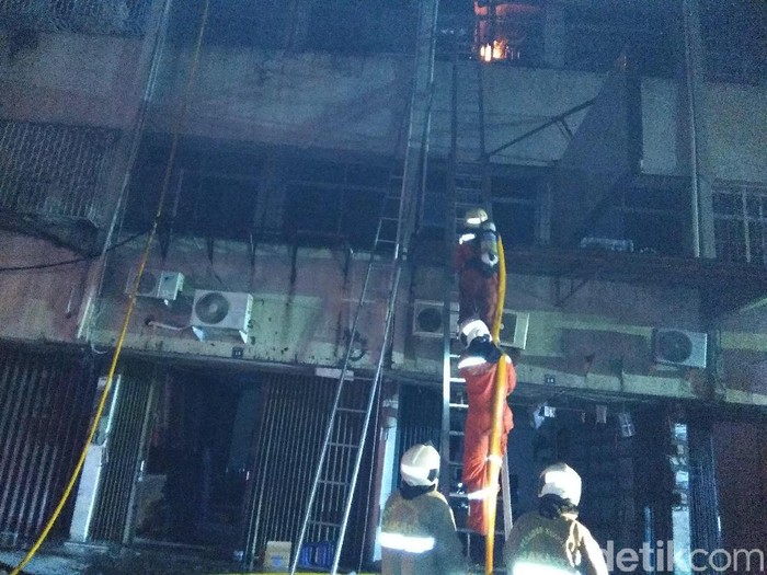Petugas damkar memadamkan api di ruko tekstil Tanah Abang, Jakarta.
