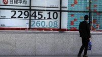 Seorang pria berjalan melewati papan stok elektronik yang memperlihatkan indeks Nikkei 225 Jepang di sebuah perusahaan sekuritas di Tokyo, Jumat, 31 Januari 2020. Saham-saham bercampur di Asia setelah Organisasi Kesehatan Dunia (WHO) mengumumkan wabah virus baru yang telah menyebar dari Tiongkok, China menyebar lebih ke banyak negara di dunia dan menyatakan darurat global. Foto: AP Photo/Eugene Hoshiko