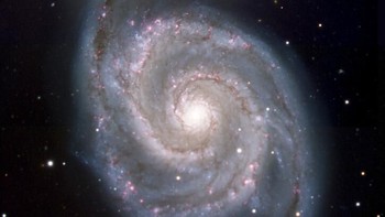 Penampakan galaksi Whirlpool, yang sebenarnya adalah sepasang galaksi Messier 51 dan NGC 5194/5195, sekitar 23 juta tahun cahaya dari Bumi. Foto NASA/JPL-Caltech via AP.   