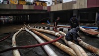 Selang-selang mengalirkan air dalam proses penyedotan banjir.