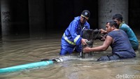 Petugas bahu membahu menyedot air.