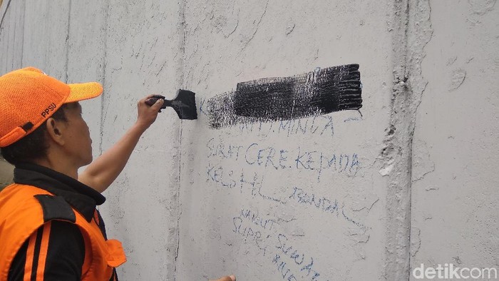 Petugas mengecat ulang underpass Tanah Abang yang dicoreti pelajar/Kadek Melda