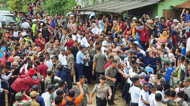  Jokowi yang berjalan di tengah kerumunan warga lalu membagi-bagikan buku dan kaos.