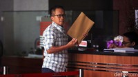 Ia tampak membawa map berwarna cokelat.