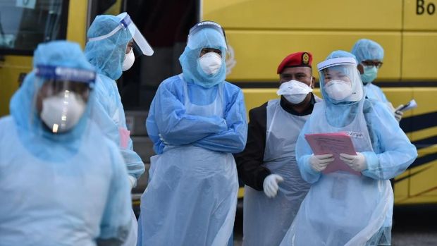 Petugas medis yang mengenakan pakaian pelindung menyambut warga Malaysia yang baru tiba dari Wuhan