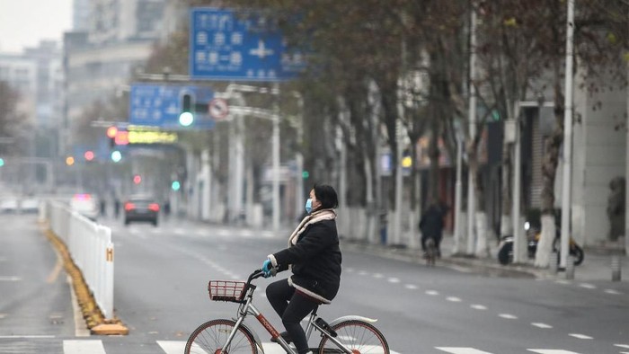 1197725319 WUHAN, CHINA - JANUARY 31: (CHINA OUT) A man wears a protective mask as he ride a bicycle across the Yangtze River Bridge on January 31, 2020 in Wuhan, China. World Health Organization (WHO) Director-General Tedros Adhanom Ghebreyesus said on January 30 that the novel coronavirus outbreak has become a Public Health Emergency of International Concern (PHEIC). (Photo by Stringer/Getty Images)