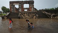 Sejumlah anak bermain di area situs cagar budaya Keraton Kaibon yang terendam banjir di kawasan Kasemen, Serang, Banten, Selasa (4/2/2020).