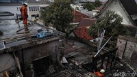 Petugas melakukan pendinginan setalah api berhasil dipadamkan.