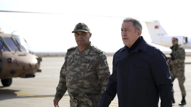 Turkey's National Defence Minister Hulusi Akar, right, arrives to inspect troops at the border with Syria, in Hatay, Turkey, Monday, Feb. 3, 2020. Turkey hit targets in northern Syria, responding to shelling by Syrian government forces that killed at least eight Turkish military personnel, Turkish President Recep Tayyip Erdogan said Monday. A Syrian war monitor said 13 Syrian troops were also killed.(Turkish Defence Ministry via AP, Pool)