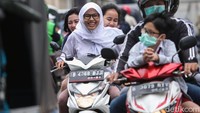 Sejumlah pelajar tampak tak mengenakan helm dan bonceng tiga saat melintasi kawasan Petojo, Jakarta, Selasa (4/2/2020).