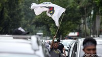 Bendera-bendera organisasi driver turut dikibarkan di tengah-tengah mobil yang diparkir.