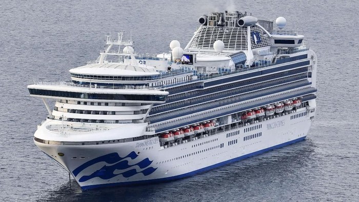 A cruise ship Diamond Princess anchors off the Yokohama Port upon arrival in Yokohama, near Tokyo Tuesday, Feb. 4, 2020. A person who was a passenger on the Japanese-operated cruise ship has tested positive for a new virus after leaving the ship in Hong Kong on Jan. 25. The ship returned to Yokohama carrying 3,000 passengers and crew members after making port calls in Vietnam, Taiwan and Okinawa. A team of quarantine officials and medical staff boarded the ship on Monday night and began medical checks of everyone on board, a health ministry official said on condition of anonymity, citing department rules. (Kyodo News via AP)