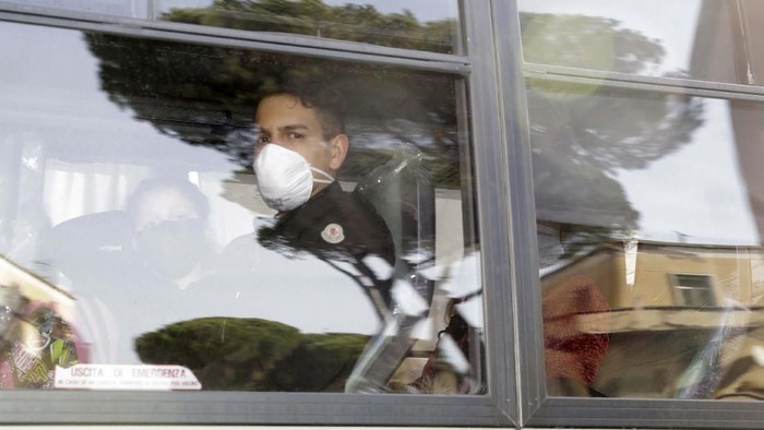 Terkait Corona, 56 Warga Italia Dikarantina di Pangkalan Militer Two military buses carrying Italians evacuated from Wuhan, China, leave the military airport of Pratica di Mare, on the outskirts of Rome, Monday, Feb. 3, 2020. An Italian military aircraft carrying the Italians landed Monday morning at a military airport near Rome, and from there all 56 people, including six children, were being transferred to a military base where they will remain in quarantine for 14 days. (Cecilia Fabiano/LaPresse via AP)