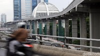 Seorang pengendara motor melintas di area sekitar proyek pembangunan LRT di kawasan Gatot Subroto, Jakarta, Selasa (4/2/2020).