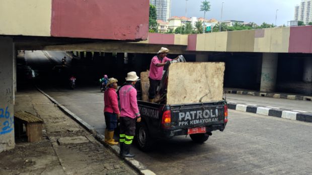 Petugas kebersihan membersihkan sampah-sampah sisa banjir.