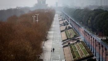 Dua warga terlihat menyusuri taman Jiangtan yang tampak kosong. Foto: Getty Images