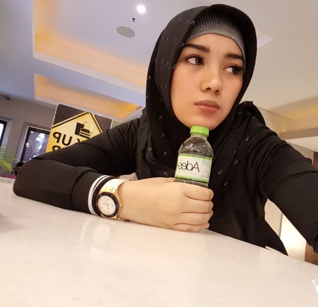 Dalam foto ini Bebi Silvana tampak cantik saat menggunakan hijab motif dan blouse warna hitam, yang ia padukan dengan inner warna abu-abu. Foto: instagram @bebi.silvana