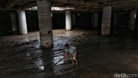 Meski telah surut, sejumlah warga dan petugas tampak sibuk membersihkan lumpur yang tersisa akibat banjir di underpass tersebut.
